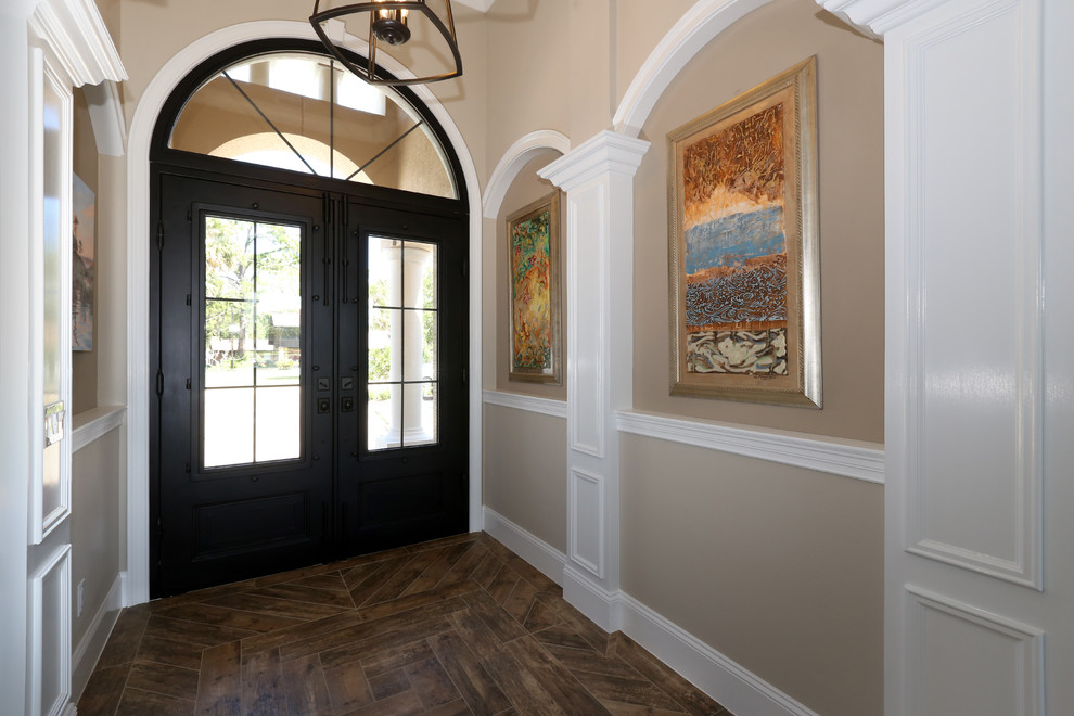 Foto de puerta principal clásica de tamaño medio con paredes beige, suelo de baldosas de porcelana, puerta doble, puerta metalizada y suelo marrón