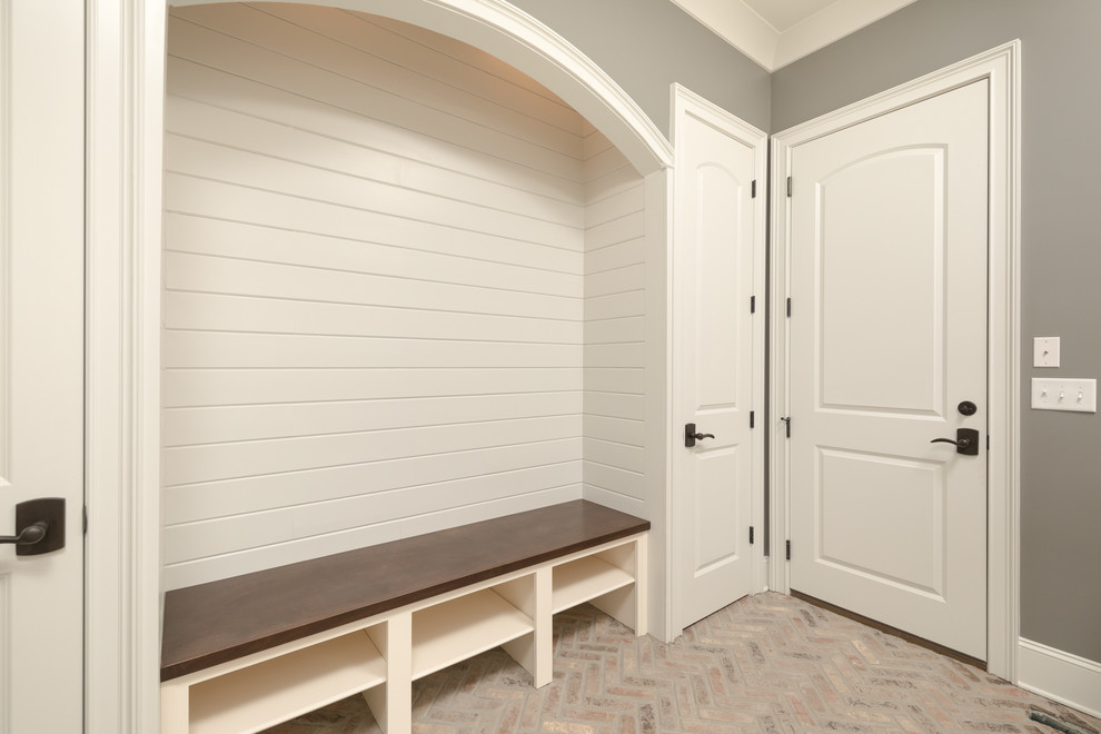 Modelo de entrada clásica de tamaño medio con paredes grises y suelo de ladrillo