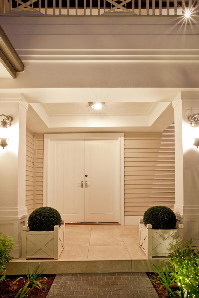Immagine di una grande porta d'ingresso classica con pareti beige, pavimento in pietra calcarea, una porta a due ante e una porta bianca