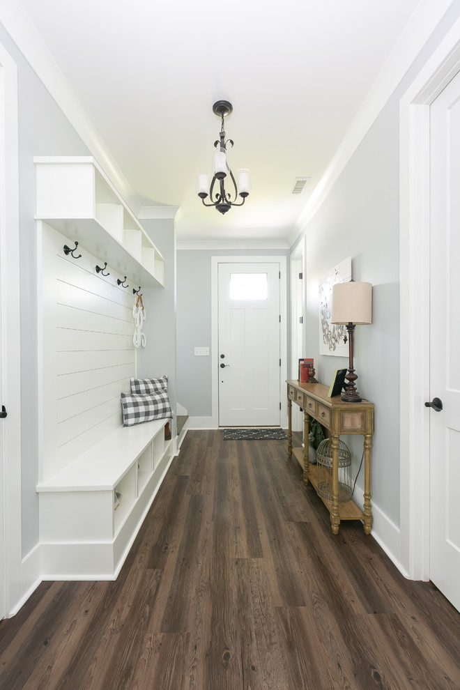 Стильный дизайн: узкая прихожая в стиле кантри с серыми стенами, темным паркетным полом, одностворчатой входной дверью, белой входной дверью и коричневым полом - последний тренд