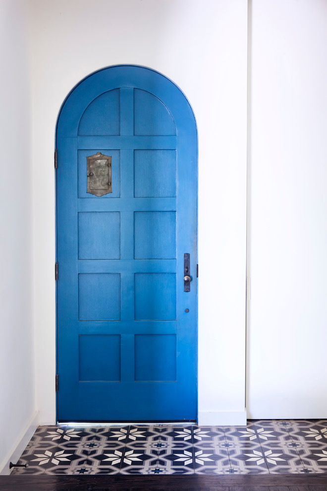 Esempio di un ingresso minimal di medie dimensioni con pareti bianche, pavimento in gres porcellanato, una porta singola e una porta blu