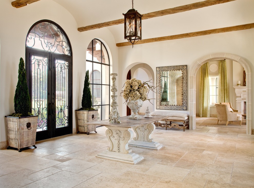 Example of a huge tuscan entryway design in Dallas with a glass front door