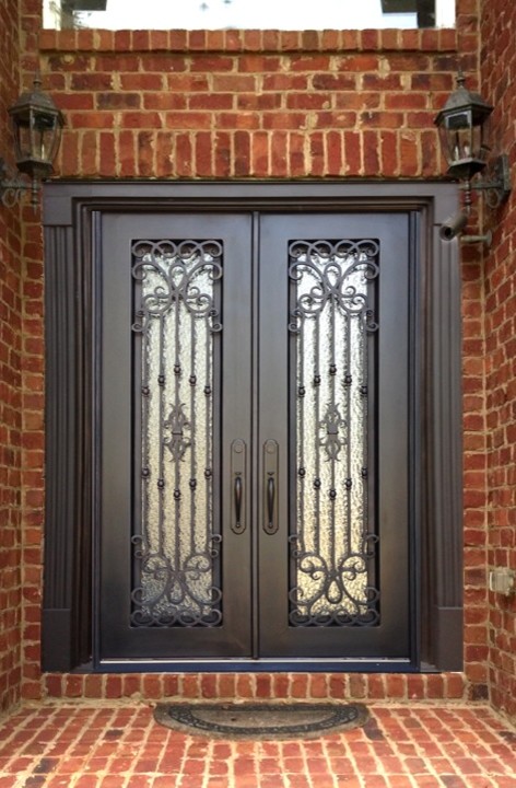 Cette image montre une porte d'entrée traditionnelle avec une porte double et une porte métallisée.