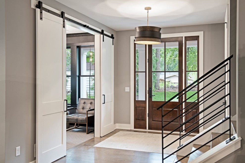 Mittelgroße Klassische Haustür mit grauer Wandfarbe, braunem Holzboden, Einzeltür, hellbrauner Holzhaustür und beigem Boden in Minneapolis