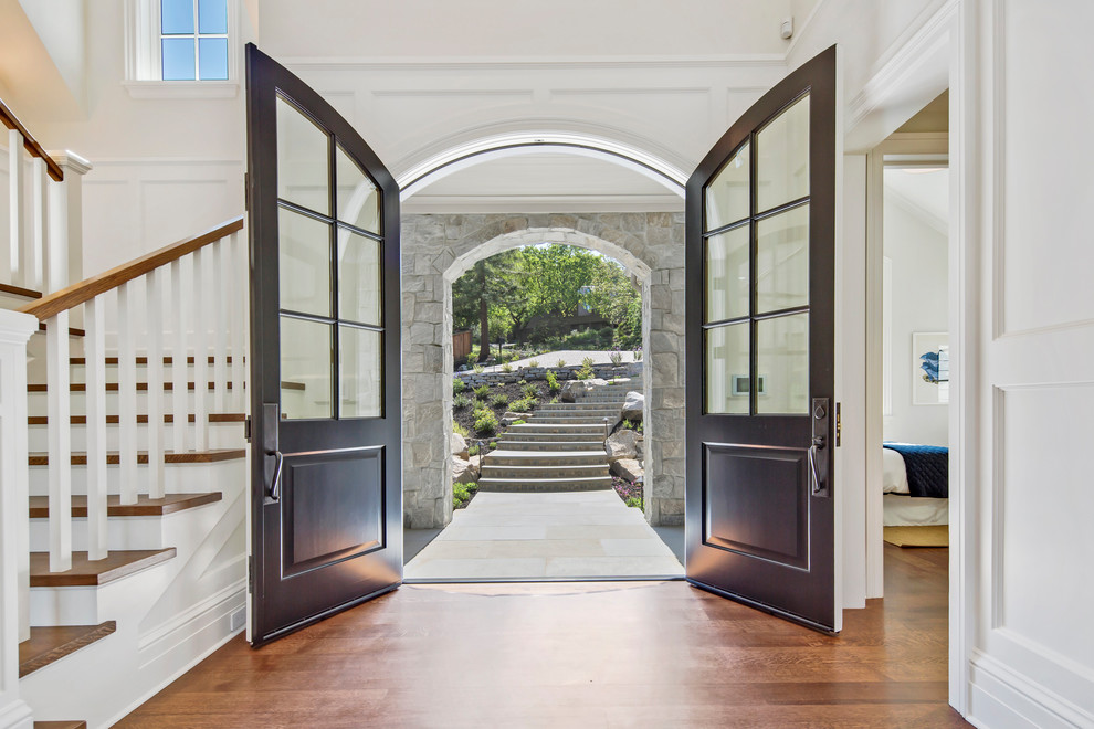 Photo of a large traditional front door in San Francisco with white walls, medium hardwood flooring, a double front door, a black front door and brown floors.