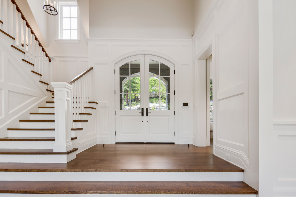Example of a large transitional medium tone wood floor and brown floor entryway design in San Francisco with white walls and a black front door