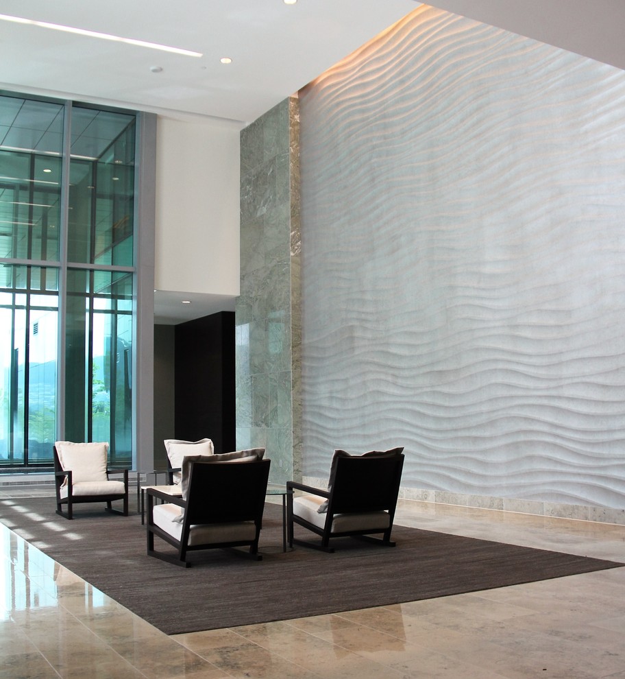Aménagement d'une très grande entrée moderne avec mur métallisé et un sol en marbre.