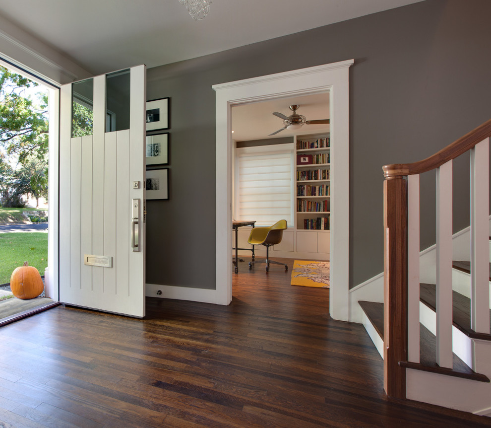 Diseño de entrada tradicional con paredes grises, puerta simple, puerta blanca y suelo marrón