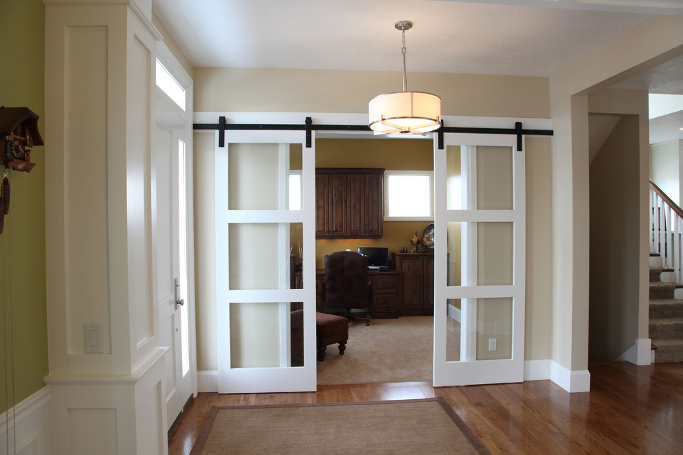 На фото: фойе среднего размера в классическом стиле с бежевыми стенами, паркетным полом среднего тона, одностворчатой входной дверью и белой входной дверью с