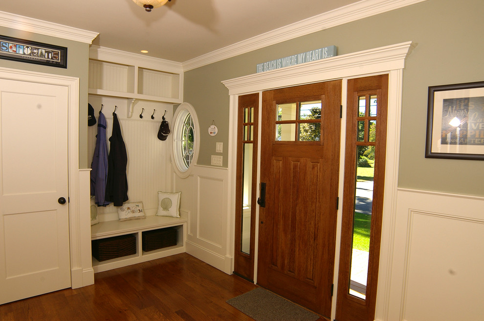 Inspiration pour une entrée traditionnelle de taille moyenne avec un vestiaire, un mur gris, parquet foncé, une porte simple, une porte en bois foncé et un sol marron.