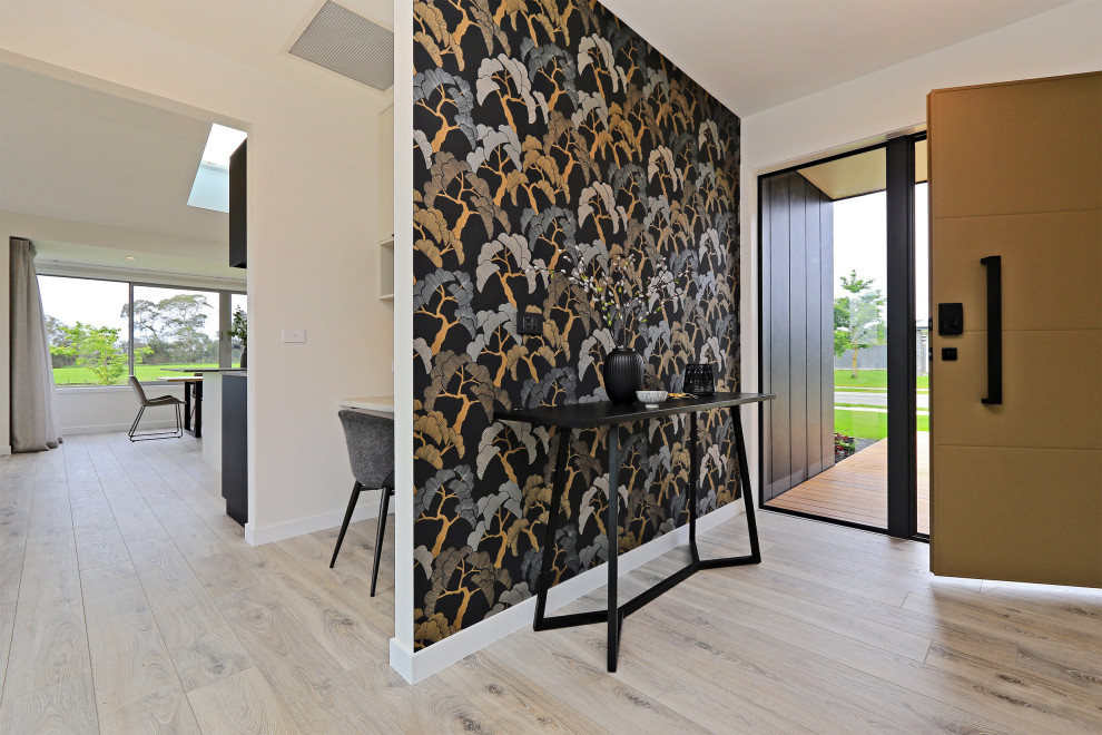 This is an example of a medium sized modern foyer in Napier-Hastings with multi-coloured walls, light hardwood flooring, a double front door, a brown front door, grey floors, wallpapered walls and a drop ceiling.