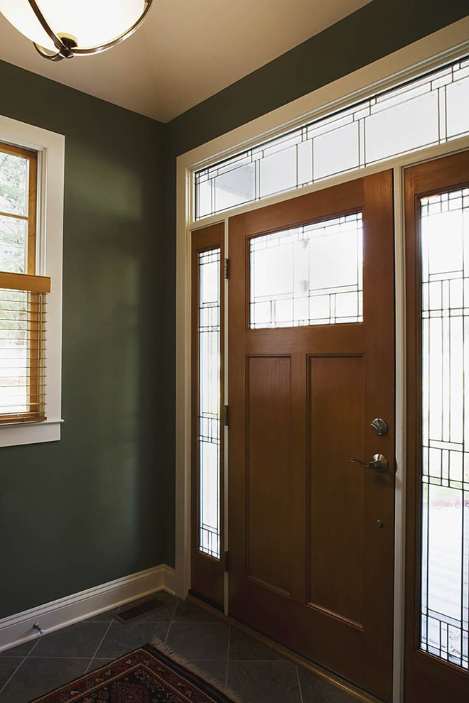 Ispirazione per un ingresso chic con pareti verdi, pavimento con piastrelle in ceramica, una porta singola e una porta in legno bruno