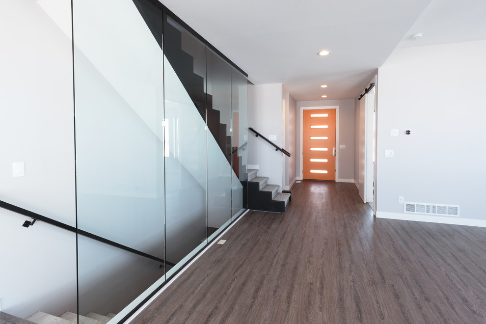 Mittelgroße Moderne Haustür mit grauer Wandfarbe, dunklem Holzboden, Einzeltür, oranger Haustür und braunem Boden in Sonstige