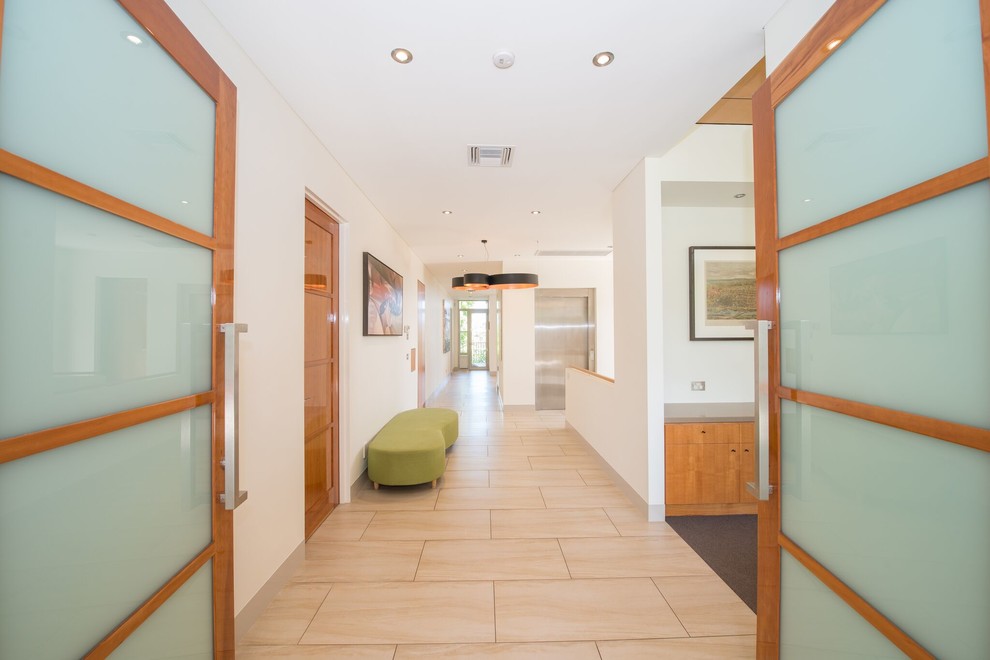 Idee per un corridoio minimalista con pareti bianche, una porta a due ante, pavimento con piastrelle in ceramica, una porta in vetro e pavimento beige