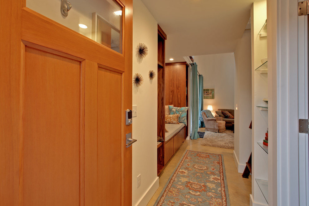 Стильный дизайн: маленькая входная дверь: освещение в стиле неоклассика (современная классика) с белыми стенами, бетонным полом, одностворчатой входной дверью и входной дверью из светлого дерева для на участке и в саду - последний тренд