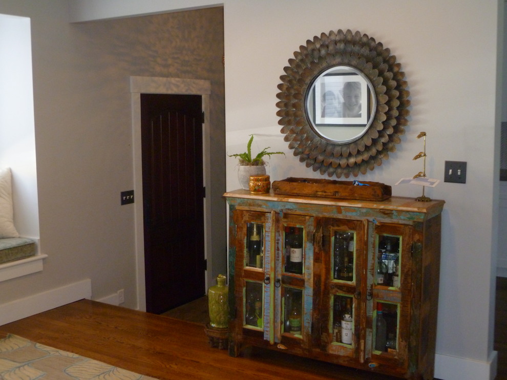 Foto de distribuidor bohemio grande con paredes grises, suelo de madera en tonos medios, puerta simple y puerta de madera oscura