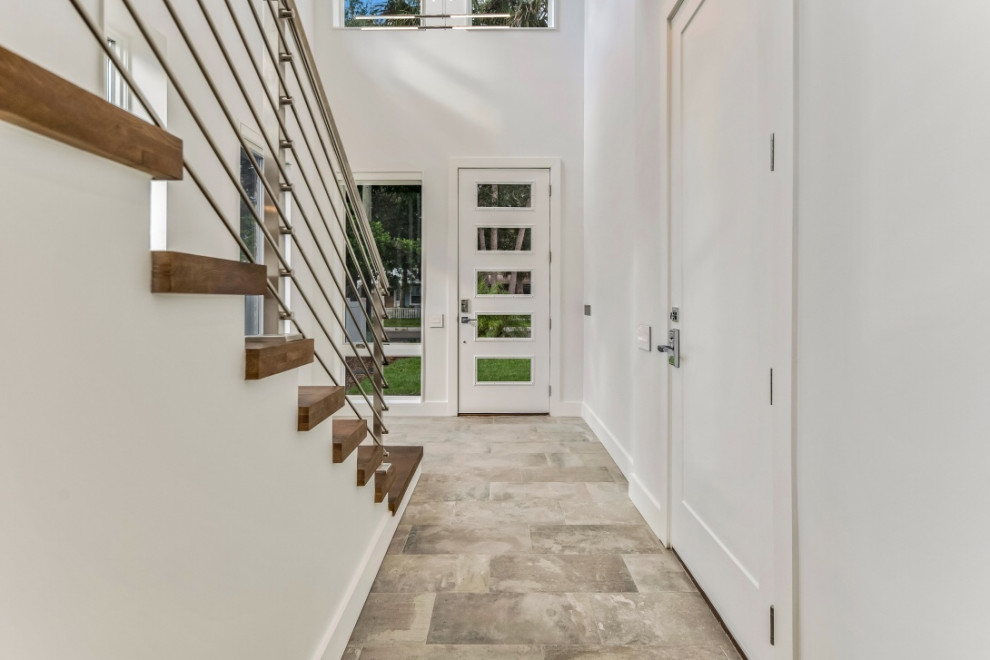中くらいなモダンスタイルのおしゃれな玄関ドア (白い壁、コンクリートの床、ガラスドア、グレーの床) の写真