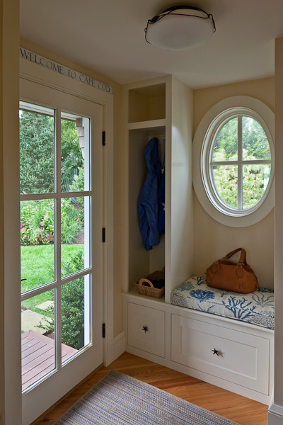 Modelo de puerta principal costera de tamaño medio con paredes beige, suelo de madera en tonos medios, puerta simple, puerta azul y suelo marrón