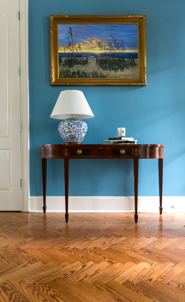 Inspiration for a timeless medium tone wood floor entryway remodel in Charleston with blue walls and a black front door