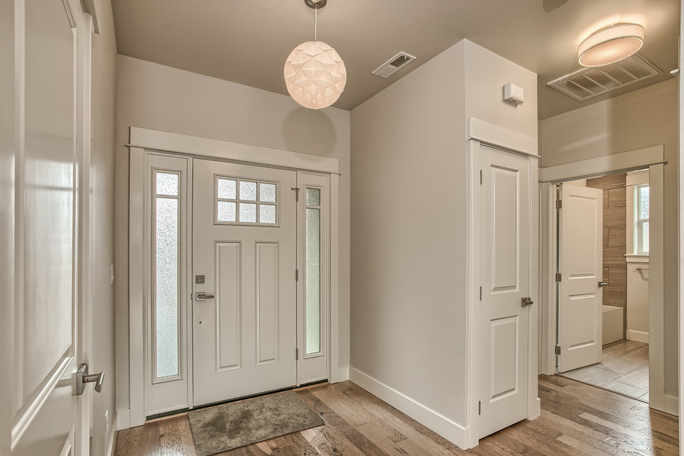 Свежая идея для дизайна: входная дверь среднего размера в стиле кантри с серыми стенами, светлым паркетным полом, одностворчатой входной дверью и белой входной дверью - отличное фото интерьера