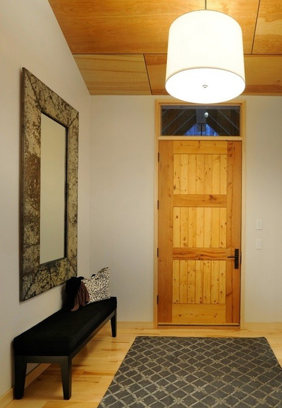 Cette photo montre une entrée avec un mur beige, parquet clair, une porte simple et une porte en bois clair.