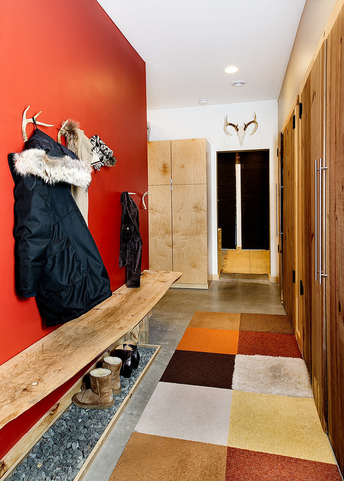 На фото: большой тамбур в стиле рустика с красными стенами, бетонным полом, серым полом, одностворчатой входной дверью и белой входной дверью с