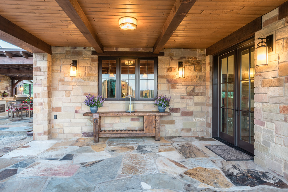 Photo of a large mediterranean front door in Austin with brown walls, limestone flooring, a double front door and a glass front door.
