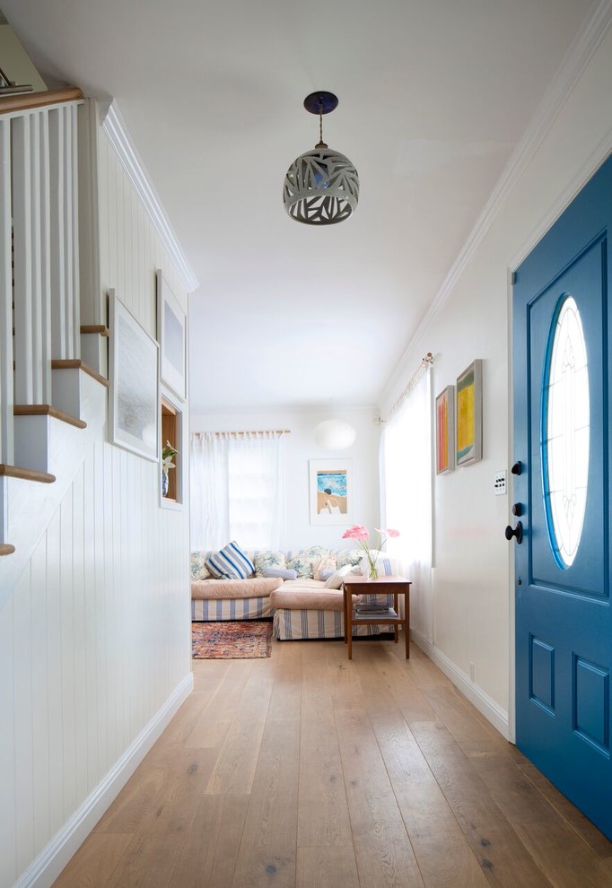 Пример оригинального дизайна: маленькая входная дверь в стиле неоклассика (современная классика) с белыми стенами, светлым паркетным полом, одностворчатой входной дверью и синей входной дверью для на участке и в саду
