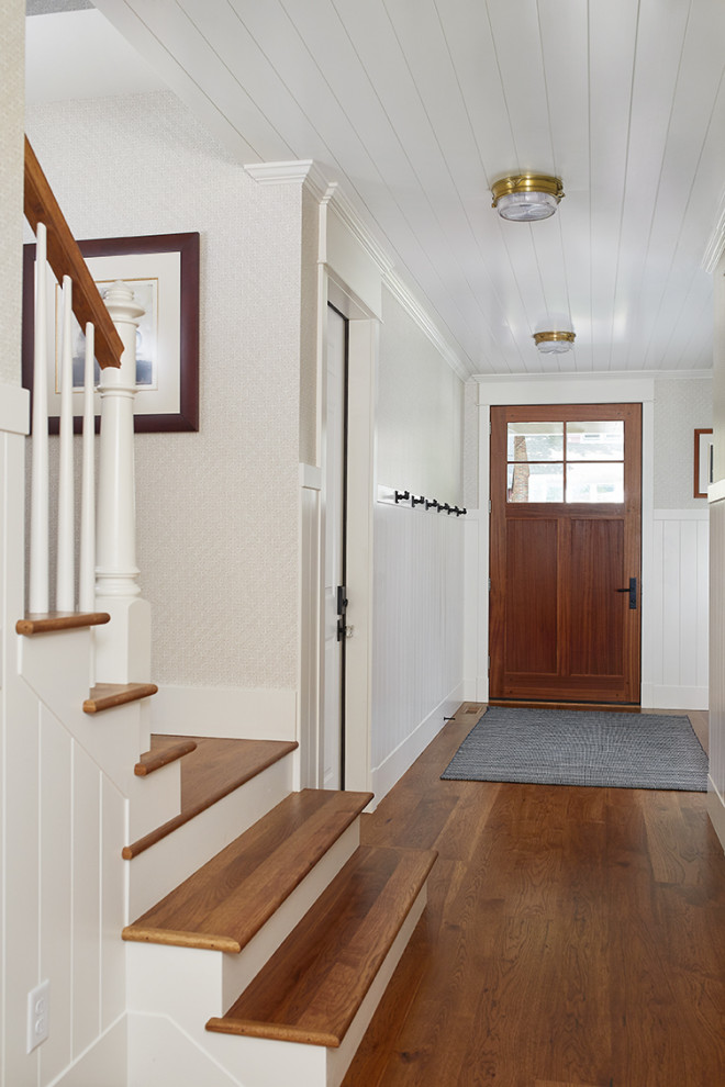 Small beach style medium tone wood floor and brown floor entryway photo in Grand Rapids with multicolored walls and a medium wood front door