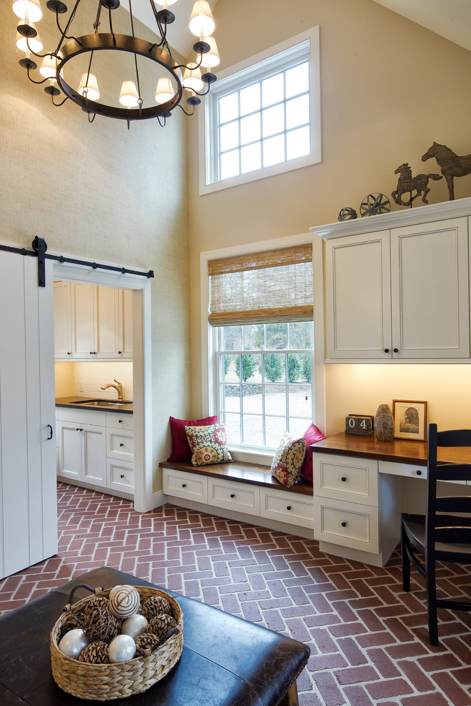 На фото: тамбур в классическом стиле с бежевыми стенами, кирпичным полом, одностворчатой входной дверью и белой входной дверью