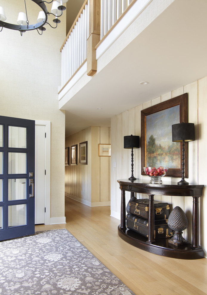 Foto di un ingresso tradizionale con pareti beige, parquet chiaro, una porta singola e una porta blu