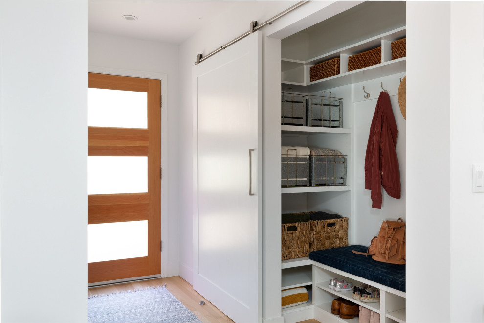Große Klassische Haustür mit weißer Wandfarbe, hellem Holzboden, Einzeltür, hellbrauner Holzhaustür und braunem Boden in Sonstige