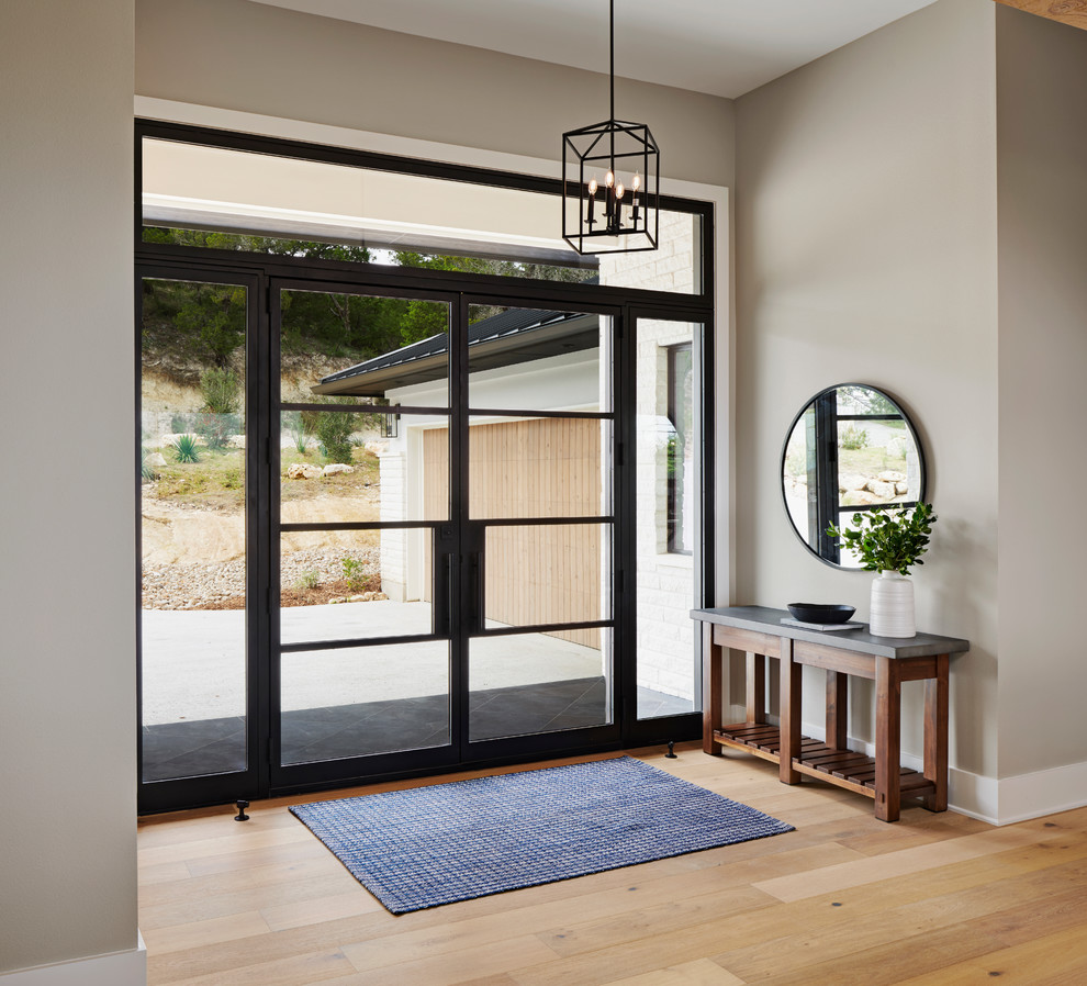 Example of a large cottage slate floor and black floor entryway design in Austin with white walls and a glass front door