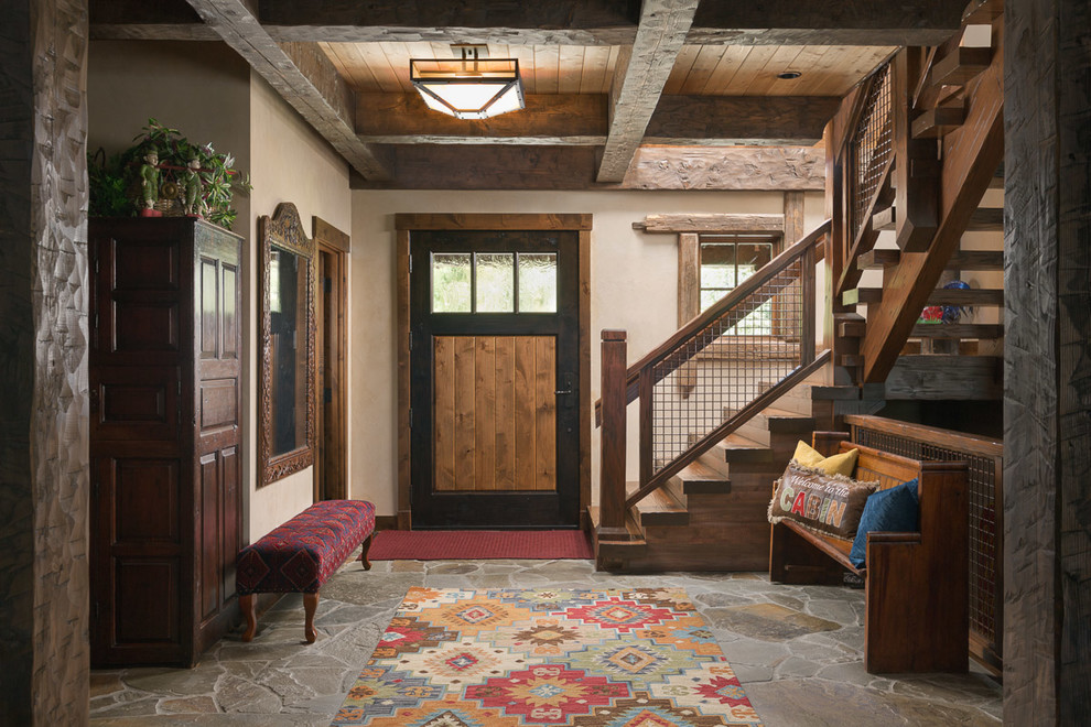 Ejemplo de puerta principal rural de tamaño medio con paredes beige, suelo de pizarra, puerta simple, puerta de madera en tonos medios y suelo gris