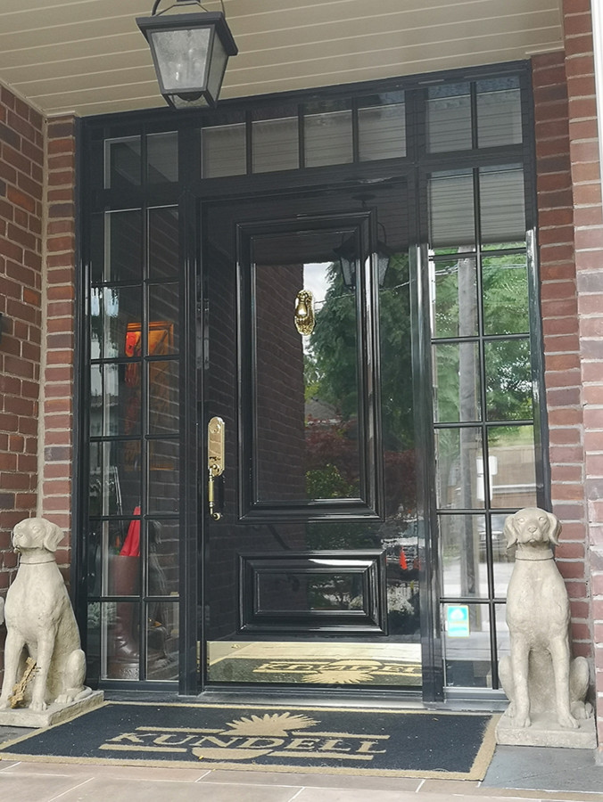 Contemporary entrance in Toronto with a single front door and a black front door.