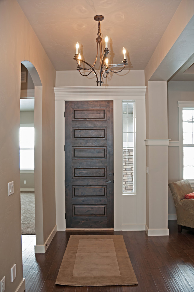Imagen de distribuidor tradicional de tamaño medio con paredes grises, suelo de madera en tonos medios, puerta simple y puerta de madera oscura