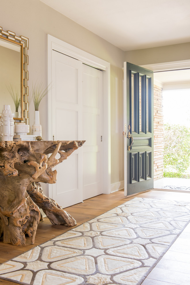 Inspiration pour une entrée vintage de taille moyenne avec un couloir, un mur beige, un sol en bois brun, une porte simple et une porte verte.