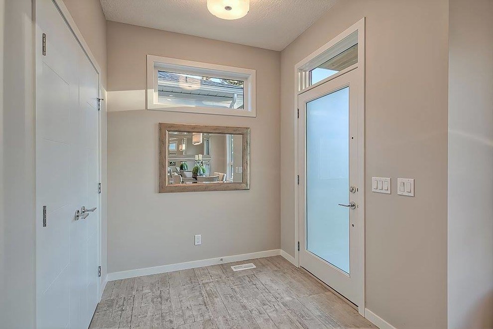 Mittelgroße Moderne Haustür mit Einzeltür, Haustür aus Glas, Sperrholzboden und grauer Wandfarbe in Calgary