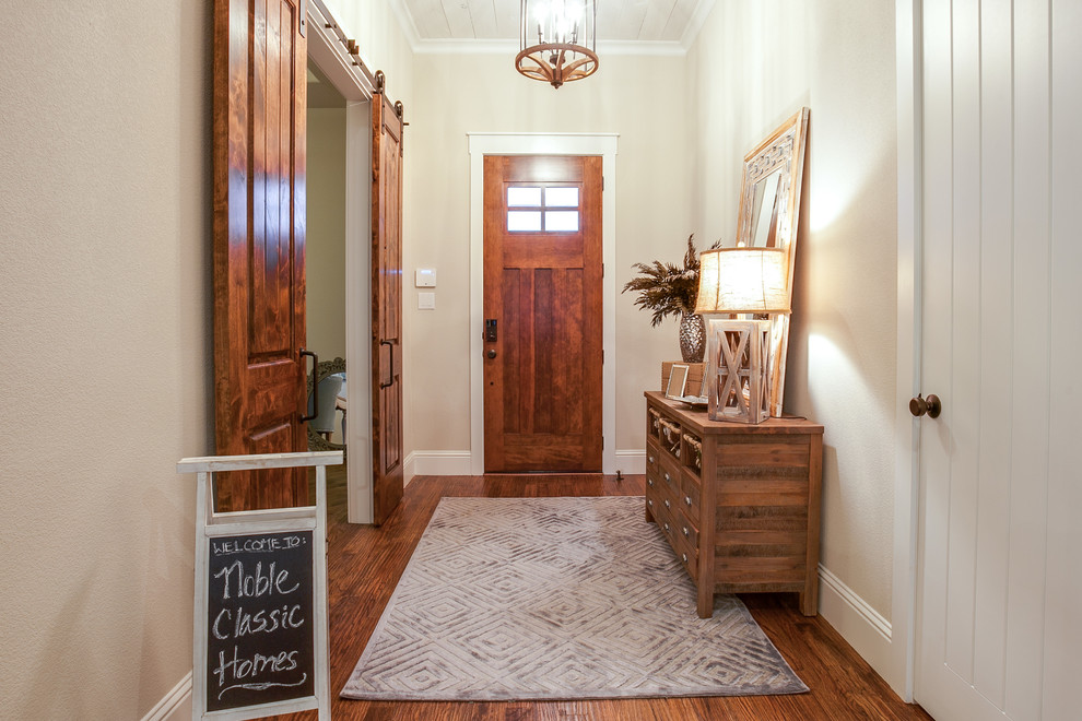 Foto de distribuidor clásico renovado de tamaño medio con paredes beige, suelo de madera en tonos medios, puerta simple y puerta de madera en tonos medios