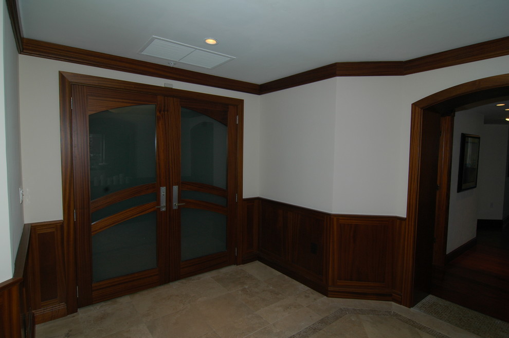 Example of a classic travertine floor entryway design in Miami with a medium wood front door