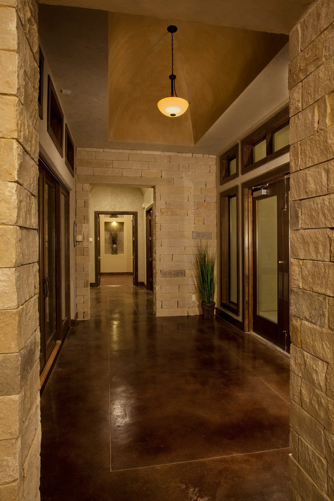 Foto di un corridoio classico con pavimento in cemento e una porta in vetro