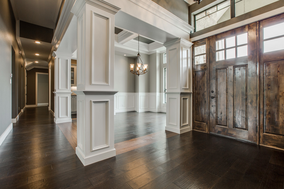 Großes Rustikales Foyer mit bunten Wänden, dunklem Holzboden, Einzeltür, dunkler Holzhaustür, braunem Boden, Kassettendecke und vertäfelten Wänden in Austin