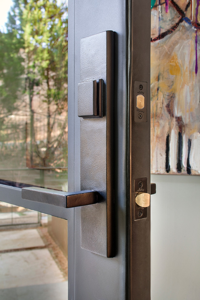 Idée de décoration pour une porte d'entrée minimaliste avec une porte simple et une porte métallisée.