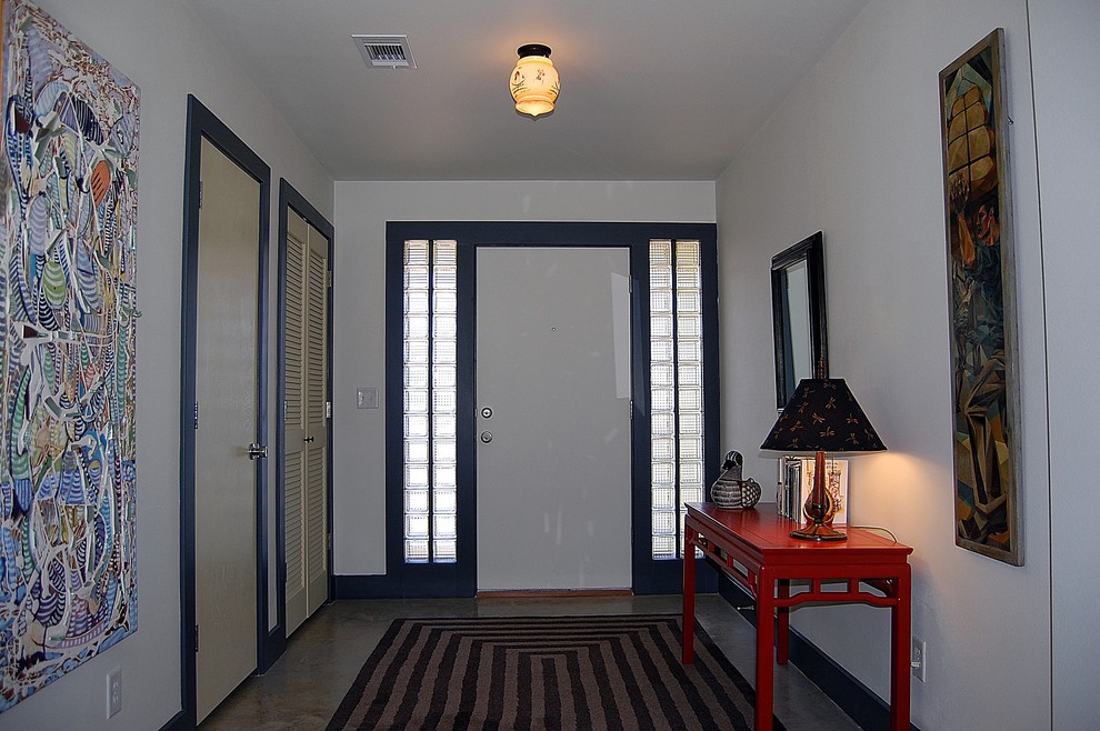 Idee per una porta d'ingresso tradizionale di medie dimensioni con pareti bianche, pavimento in cemento, una porta singola, una porta grigia e pavimento grigio
