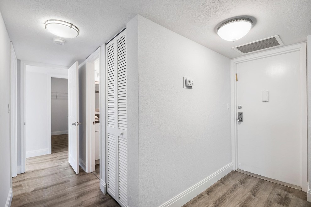 Mittelgroße Maritime Haustür mit grauer Wandfarbe, hellem Holzboden, Einzeltür, weißer Haustür und braunem Boden in Miami