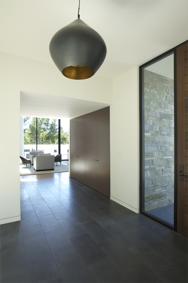 Foto di un ingresso o corridoio minimalista con pareti bianche, pavimento con piastrelle in ceramica e armadio