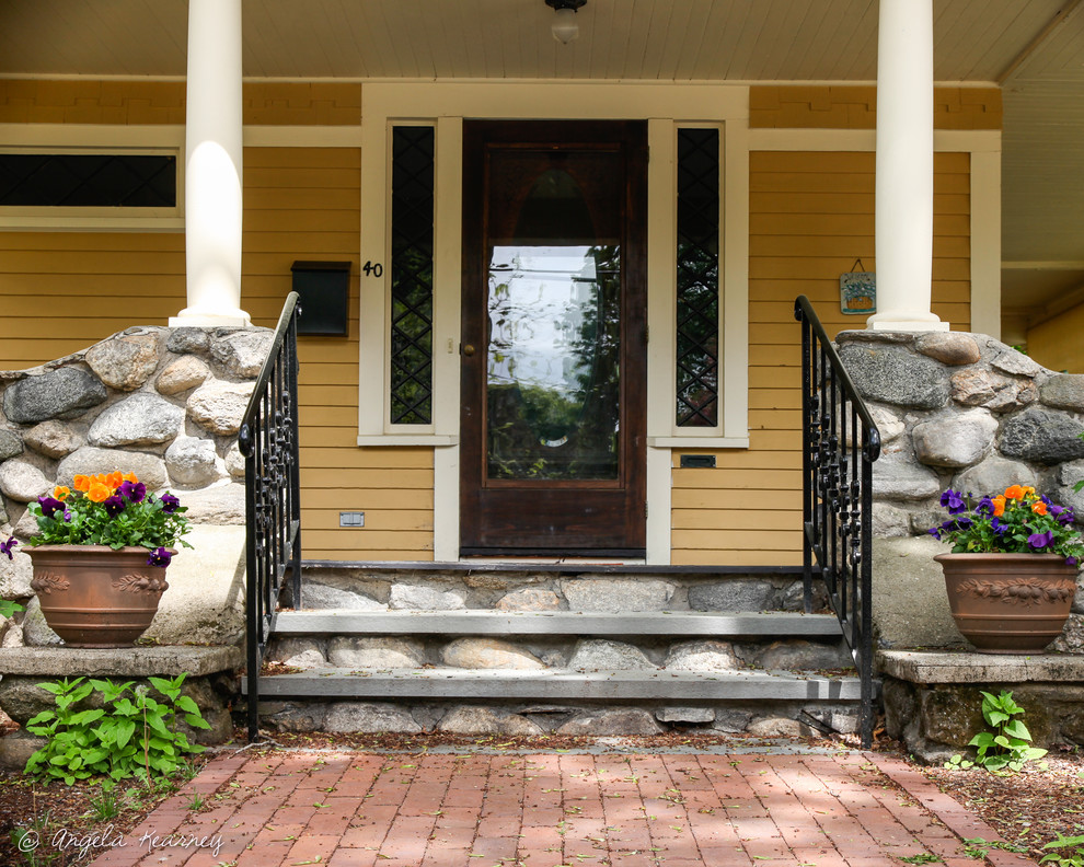 Example of a mid-sized classic entryway design in Boston with yellow walls and a dark wood front door