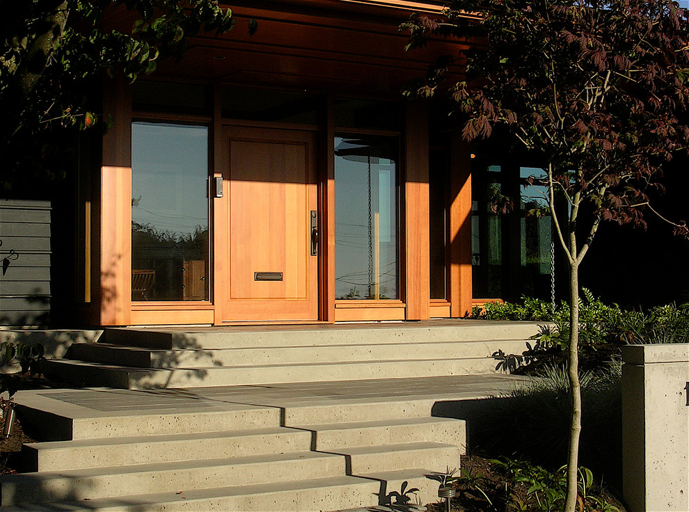 Diseño de puerta principal contemporánea con puerta simple, puerta de madera clara y suelo gris