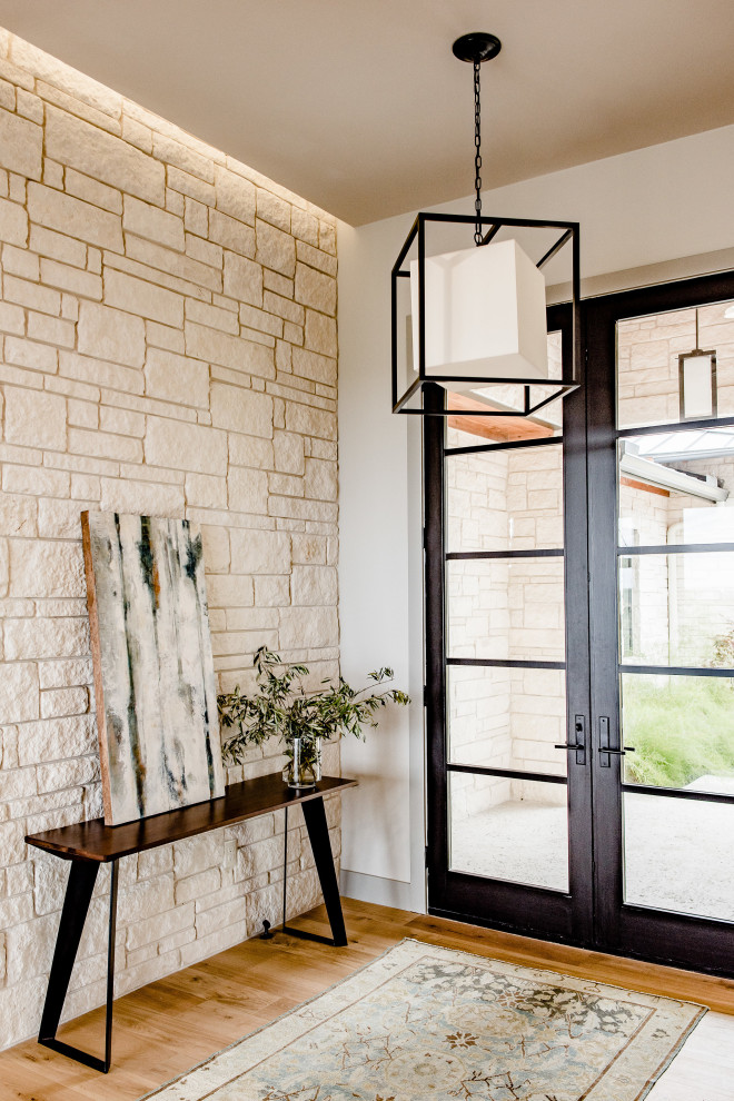 Immagine di un ingresso o corridoio minimal con pareti beige, pavimento in legno massello medio, una porta a due ante, una porta in vetro e pavimento marrone