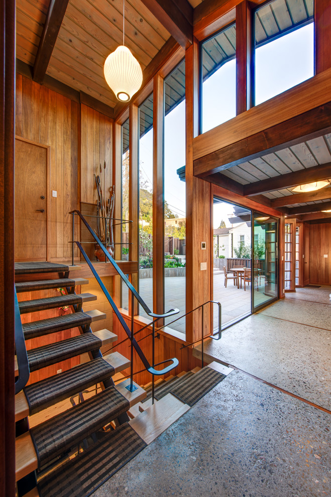 Cette image montre un hall d'entrée vintage avec sol en béton ciré, une porte simple et une porte en bois brun.